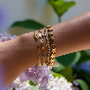 Layered gold stainless steel star bracelet set with cubic zirconia on woman wrist