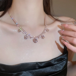 Close-up of rose gold zircon heart tassel necklace on model highlighting elegant collarbone
