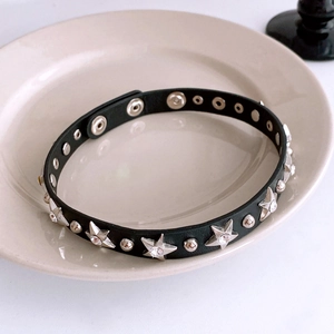 Close-up of black leather choker with silver star crystals and adjustable snap buttons