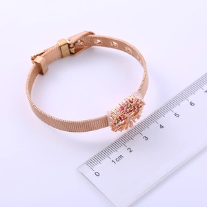 Detail of rose gold tree of life charm with colorful gems and mesh watch band strap