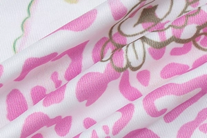 Gros plan sur un tissu en polyester doux avec imprimé léopard rose et motifs verts