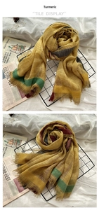Detail of ginger wool scarf featuring striped patterns and natural frayed edges