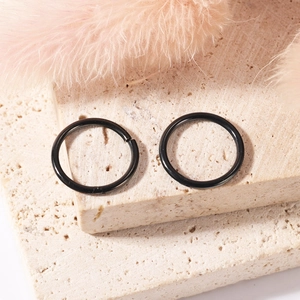 Macro shot of two polished black 316L stainless steel hinged rings for body piercing