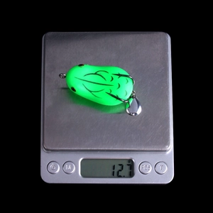 Green frog fishing lure on electronic scale weighing 12.7g for snakehead fishing