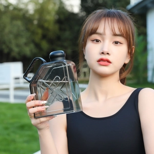 Outdoor detail of a dark transparent square fitness water jug with geometric facets
