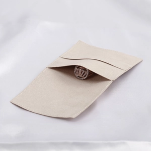 Close-up of beige velvet jewelry pouch with elegant microfiber texture and crown ring detail