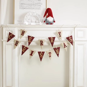 Merry Christmas banner with red plaid and beige linen flags hanging on a white fireplace