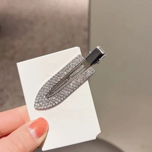 Detail of silver metal hair clip with sparkling rhinestones on a white display card