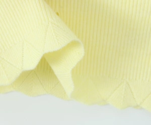 Primer plano detallado del tejido de punto amarillo pálido con texturas geométricas
