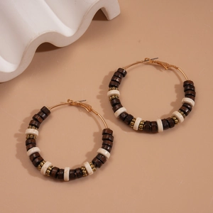 Detail of bohemian round earrings featuring dark wood beads and white marble-textured beads