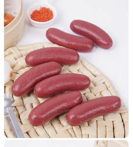 Realistic hollow artificial sausages on a woven mat used for pet decor and food props