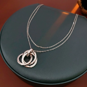 Detailed view of intertwined rose gold rings pendant with cubic zirconia on jewelry tray