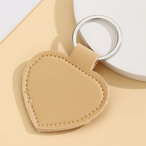 Detail of a beige heart-shaped PU leather keychain with high-quality metal ring