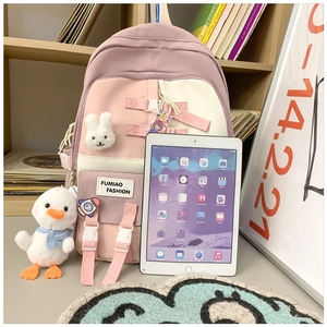 Pink and white school backpack with cute plush charms and multiple storage compartments