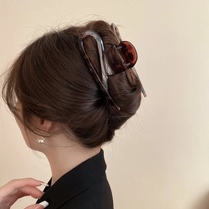 Detail showing high-quality tortoiseshell claw clip securing a full hair bun from behind