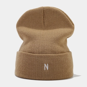 Detail of tan ribbed knit beanie featuring high-quality white letter N embroidery