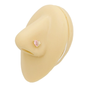 Macro view of a gold-plated nose stud with a pink pear-cut zircon on a silicone model
