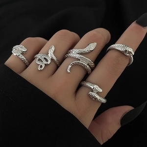 Detail of silver snake rings with textured scales and unique coiled serpent designs