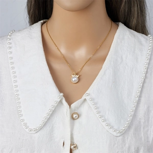 Elegant gold titanium necklace with pearl crown pendant and stones on a model