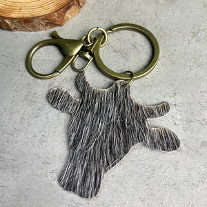Détail d'un porte-clés en cuir tête de taureau avec fourrure bicolore et métal laiton