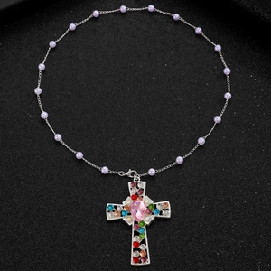 Detail of silver chain necklace with cross pendant and multi-colored rhinestones
