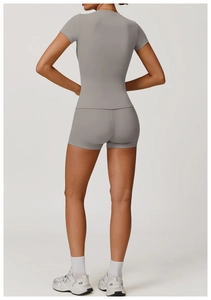 Vista posteriore di set fitness grigio con pantaloncini a vita alta e top a maniche corte