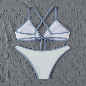 Detail of white bikini set with blue trim showing halter neck tie and molded cups