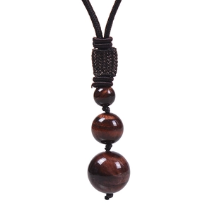 Détail de perles en pierres naturelles avec cordon tressé à la main de couleur marron