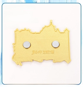 Detail of the back of a metal souvenir fridge magnet featuring dual strong magnets