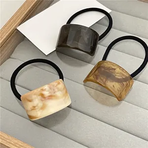 Minimalist marble resin ponytail holders in amber and cream colors for elegant hair styling