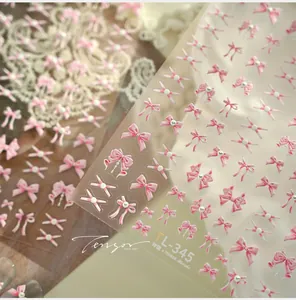 Macro view of TL-345 pink bow-knot nail stickers with pearl accents on lace background