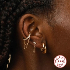 Detail of gold S925 sterling silver ear cuff set with CZ diamonds and chain fringe