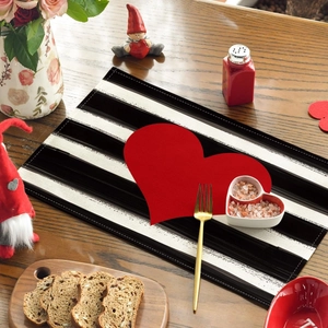 Valentine's Day table mat with black stripes and red heart on a wooden dining table