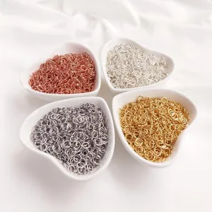Detail of multi-color jump rings for jewelry making in heart-shaped ceramic dishes
