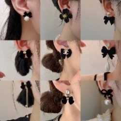 Detail view of vintage black velvet bow earrings with camellia flower and pearl charms