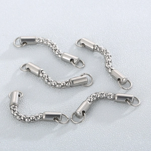 Five silver stainless steel textured jewelry connectors for necklace making on gray surface
