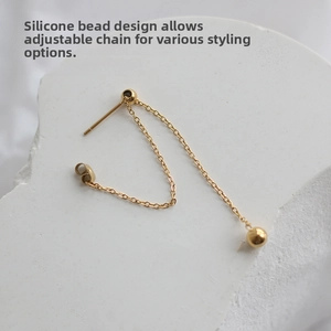 Detail of adjustable gold chain earring with sliding silicone bead for versatile styling