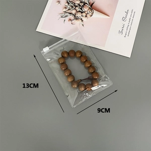 Detail view of 13x9cm clear plastic jewelry storage bag with sliding zipper lock