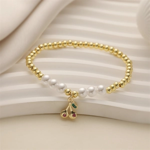 Bracelet perlé avec pendentif cerise perles dorées et perles blanches sur socle ondulé