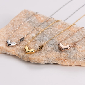 Three geometric heart necklaces in silver, gold and rose gold with letter e detail