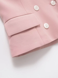 Détail de la veste rose avec texture sergée et boutons en nacre blanche