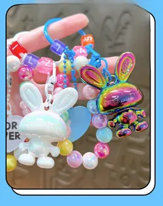 Detail of colorful acrylic rabbit keychain with iridescent and pearlescent charms