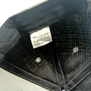 Detail view of the 100% cotton inner lining and wash care label of the houndstooth cap