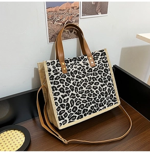 Detail of leopard print tote bag with brown faux leather handles and detachable strap