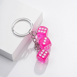 Detailed view of pink translucent resin dice charms on a polished metal keychain