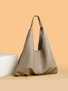 Taupe pebbled leather tote bag with minimalist shoulder strap on neutral background