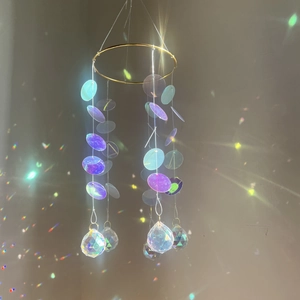 Golden suncatcher with purple crystal prism balls creating rainbow reflections on wall