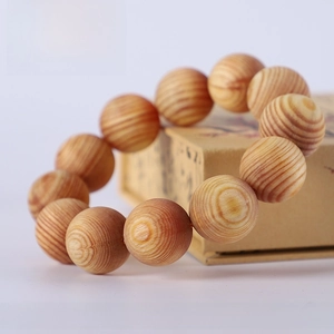 Macro detail of 20mm fatwood prayer beads with natural reddish grain and high oil texture