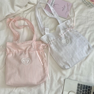Close-up of cute drawstring tote bag with heart lace applique and silk ribbon detail