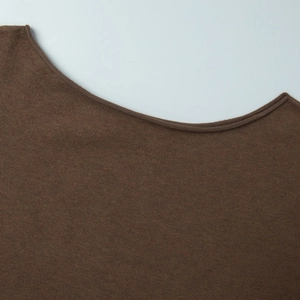 Détail du haut en tricot marron foncé avec encolure bateau et texture de maille fine